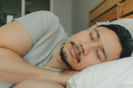 Close up Asian man sleeping on his bed with happy face . Concept of good sleep.の写真素材