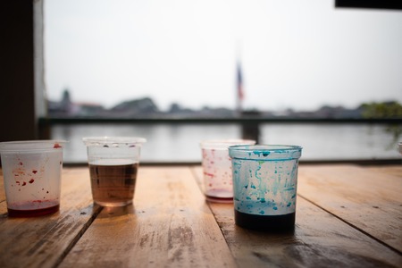 Water color in plastic cup, leftover from kids painting activity.の写真素材