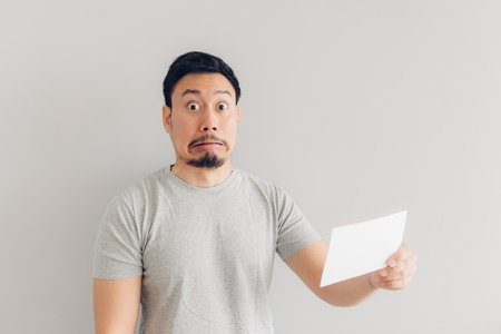 Asian man is shocked and surprised with the white mail message or the bill.の写真素材