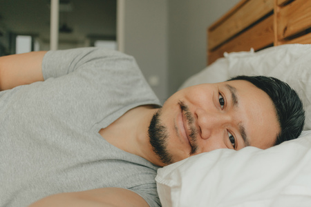 Close up Asian man sleeping on his bed with happy smile face. Concept of happy deep sleep.の写真素材
