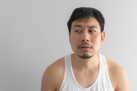 Lazy and messy Asian man in white tank top. Concept of poor and problem.の写真素材