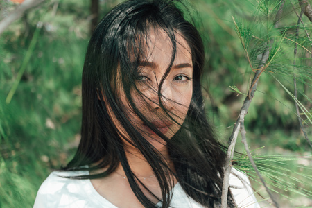 Portrait of Asian woman under the shade of pine tree in summer.の写真素材
