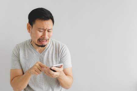 Asian man cry and sad with what show on the smartphone.の写真素材