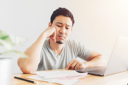 Sad Asian man has problems with billing and debts.の写真素材