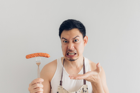 Asian man is angry on the sausage as it is not what he expected for his diet or not delicious.の写真素材