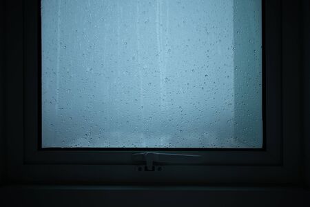 Rains falls run through the windows of the condominium room.