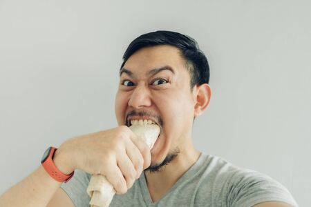 Funny face Asian man selfie himself eating homemade chicken kebab.の写真素材