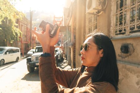 Asian woman tourist is taking photo in European town.