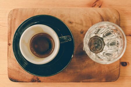 Set of espresso coffee cup with a glass of water on wooden table.の写真素材