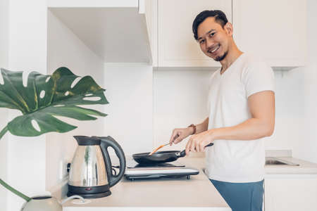 Asian man is cooking breakfast in the kitchen.の写真素材