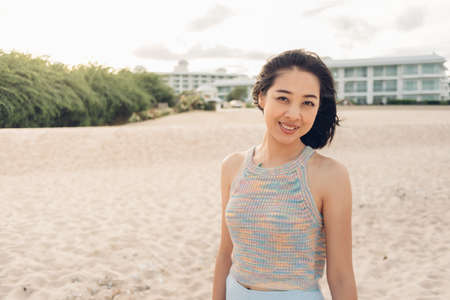 Asian woman takes a walk on the windy beach and sunny sun.の写真素材