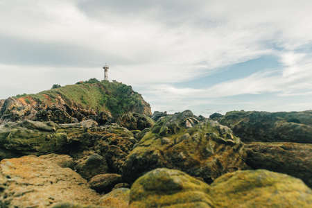 Field of reefs and with lighthouse in the background in a cloudy day.の写真素材