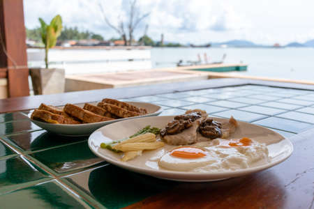 French toast and carrots juice served on the table at the balcony by the sea.の写真素材