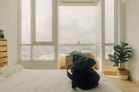 Preparing a black backpack for a trip in the bedroom.の写真素材
