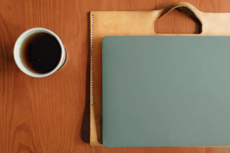 Paper cup of hot drink and laptop on the table. Concept of work from home.