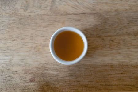 Closeup of hot tea in Chinese tea cup or Gaiwan on wooden table.の写真素材