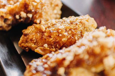 Close up of homemade crispy Korean fried chicken served on a black long dish.の写真素材