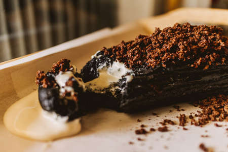 Close up of dark chocolate bread with white creamy custard in a cafe.