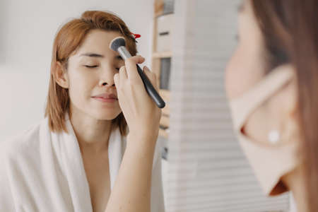 Asian woman is wearing makeup by the makeup artist.の写真素材