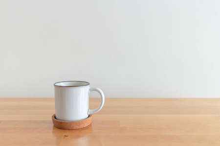 White cup of hot coffee mug on wooden table with isolate white background.の写真素材