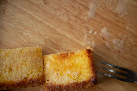 Thai Condensed Milk Toast served on wooden plate on black table.の写真素材