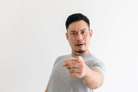 Asian man is pointing into the camera with an excited facial expression.