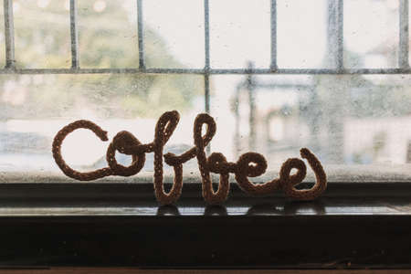 Fancy wire shaped into word COFFEE stand on the edge of cafe window.