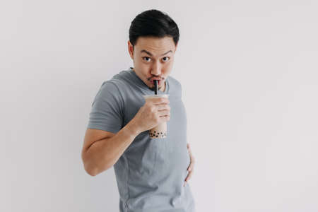 Asian man drinking boba tea or bubble tea deliciously isolated on white background.