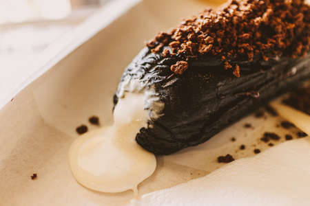 Close up of dark chocolate bread with white creamy custard in a cafe.