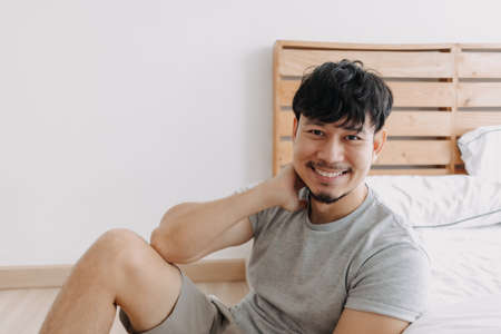 Asian man relax in his apartment while in quarantine stay at home.の写真素材