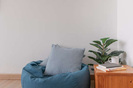 Blue bean bag in a clear living room with wooden floor and clear white wall.の写真素材