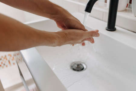 Person is washing hands in the bathroom. Concept of health and protection.の写真素材