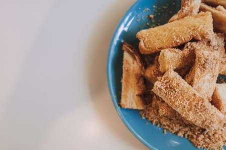 Dusty toast sticks with barbecue flavor powder served on blue ceramic dish.の写真素材