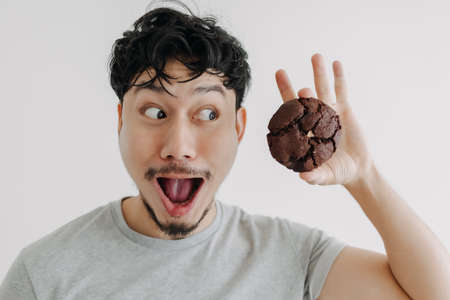 Wow and Shocked face of Asian man feels excited with the huge chocolate cookie.の写真素材