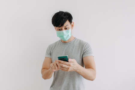 Asian man wear mask and using phone application isolated on white background.