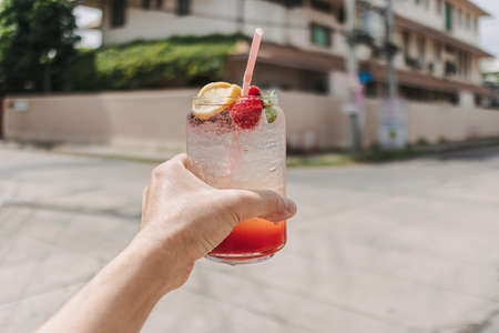 Hand holding a jar of Mixed Italian Soda. Concept of drink in summer.