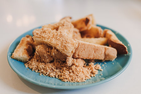 Dusty toast sticks with barbecue flavor powder served on blue ceramic dish.の写真素材