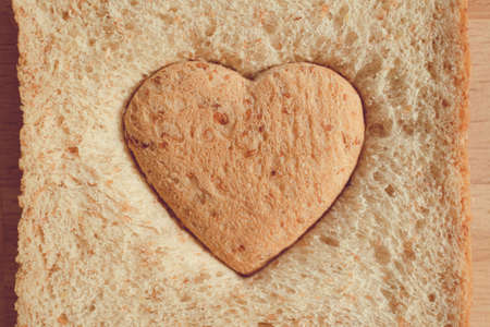Grained bread cut off as heart shape. Concept of love and care in Valentine day.の写真素材