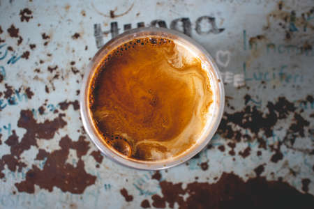 Top view of cold Dirty Latte coffee in a glass on rusty table.の写真素材