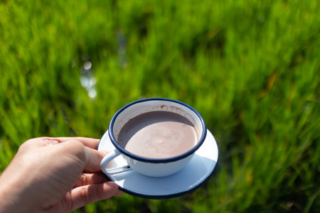 Person hold a coffee with a view of green rice field in concept of chill relax.