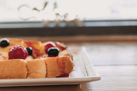 Dessert of toast bread with cherry and berry served on white dish.の写真素材