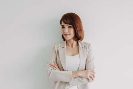 Confident Asian working woman in beige blazer isolated on white background.の写真素材