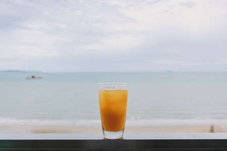 Fresh juice in a glass with sea view background in concept of summer.