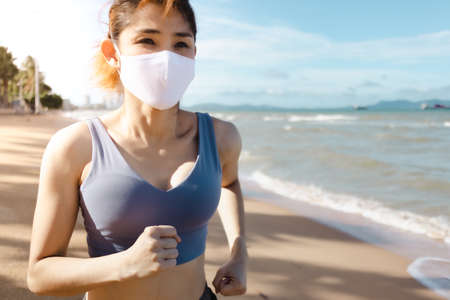 Asian woman jogging by the beach in the morning of warm summer.の写真素材