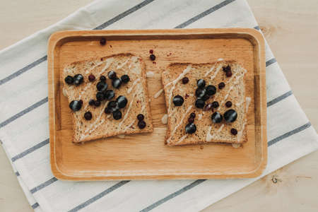 Homemade mixed berries toast breads served on wooden plate.