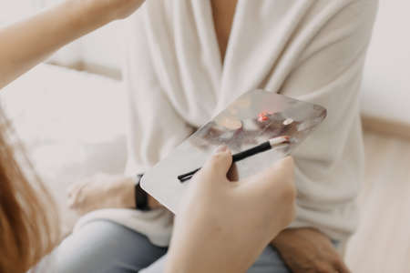 The makeup artist is using makeup tools applying to the client.の写真素材