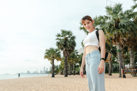 Asian woman tourist walk on the beach with palm trees on the background.の写真素材