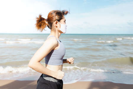 Asian woman jogging by the beach in the morning of warm summer.の写真素材
