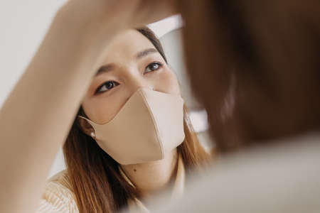 Asian woman makeup artist is at work and wearing makeup on her model.の写真素材