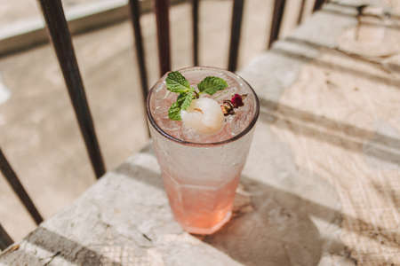 Lychee Pink Rose Italian Soda in transparent glass decorated with Mint leaves.
